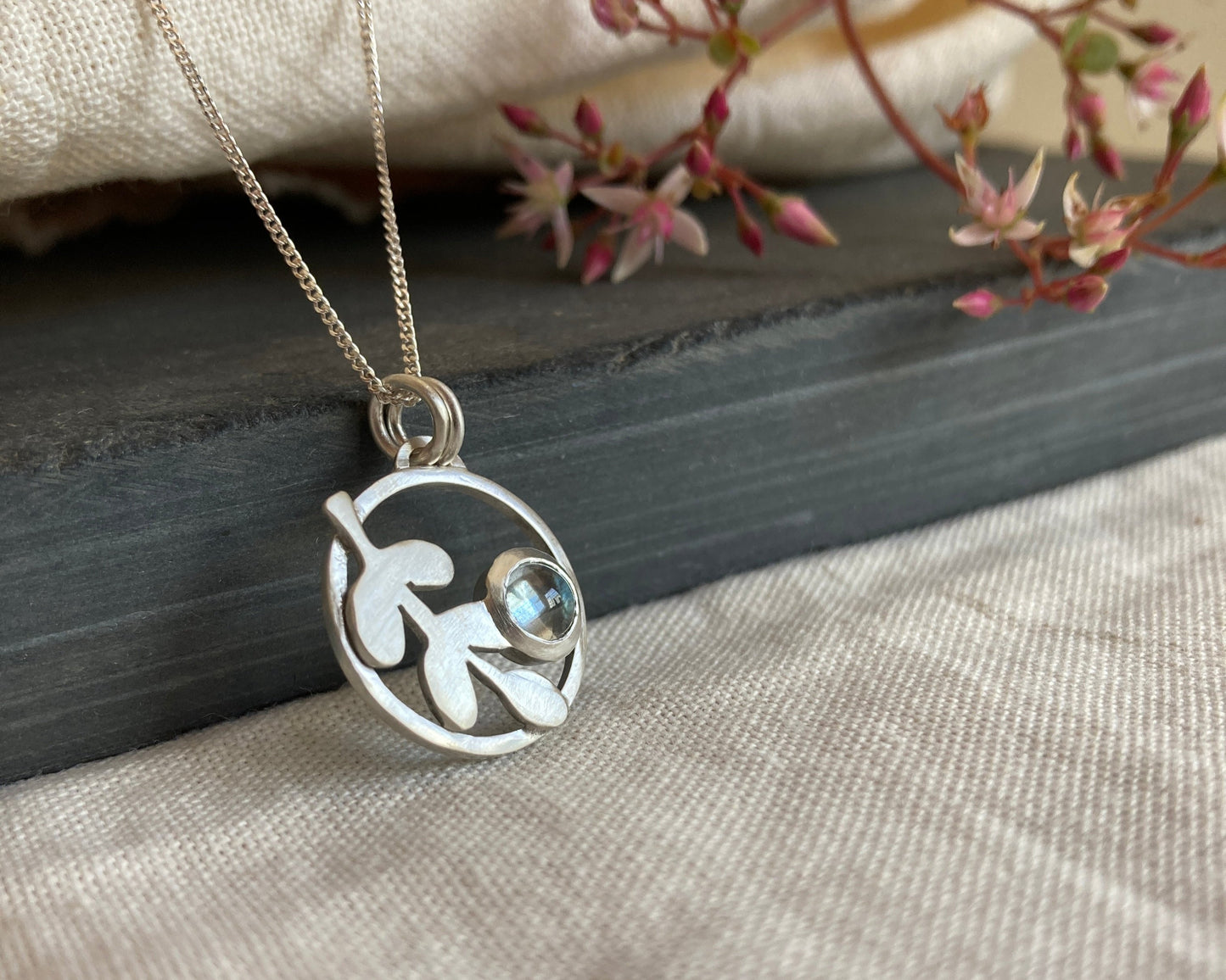 Sterling Silver Circle Pendant with Kiaat Leaves Detail and Set Blue Topaz Stone