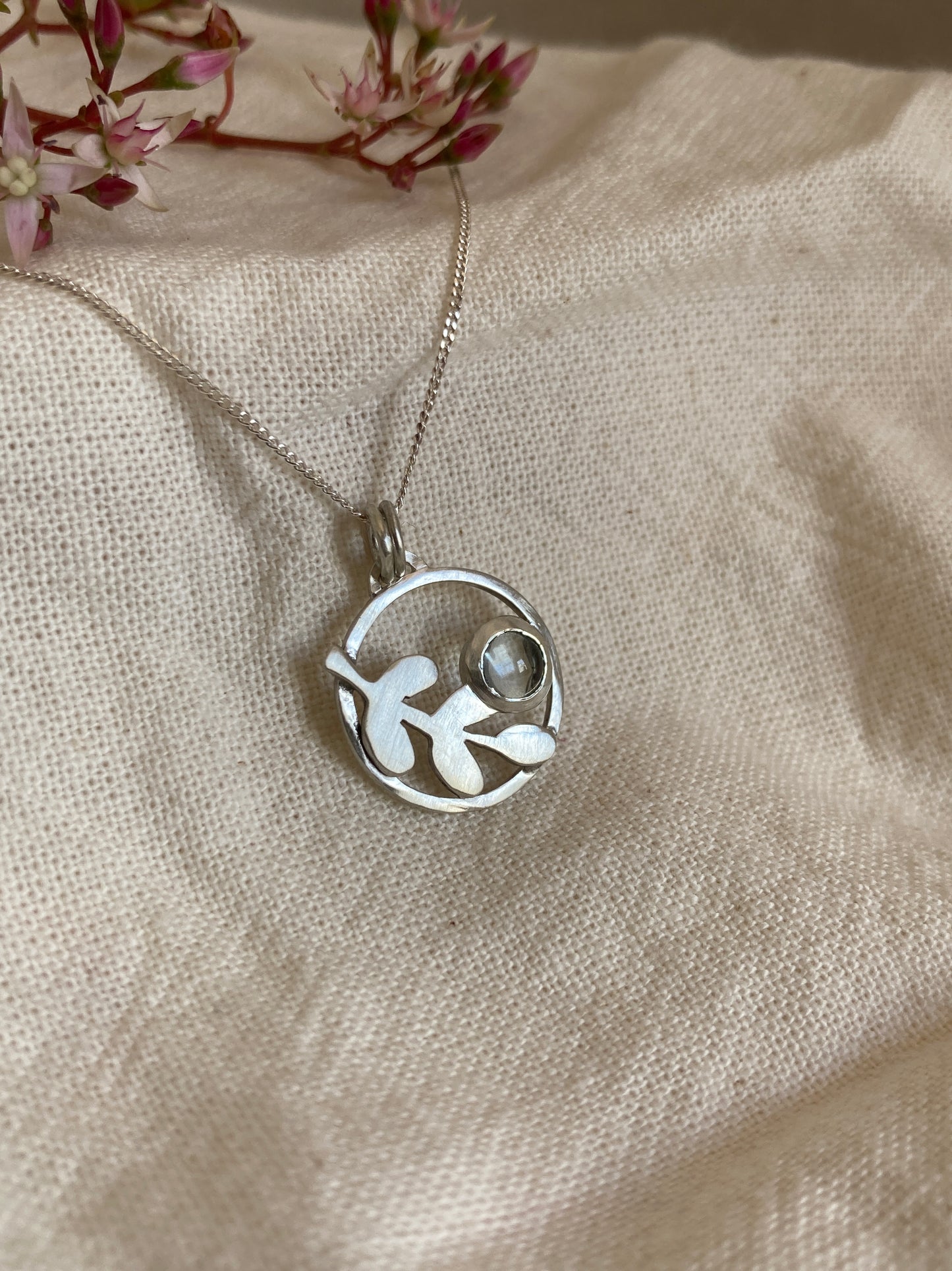 Sterling Silver Circle Pendant with Kiaat Leaves Detail and Set Blue Topaz Stone