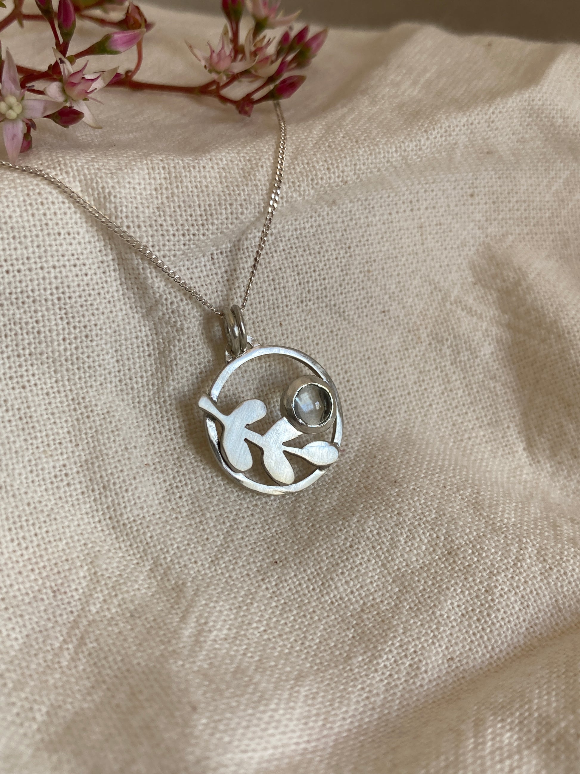 Sterling Silver Circle Pendant with Kiaat Leaves Detail and Set Blue Topaz Stone